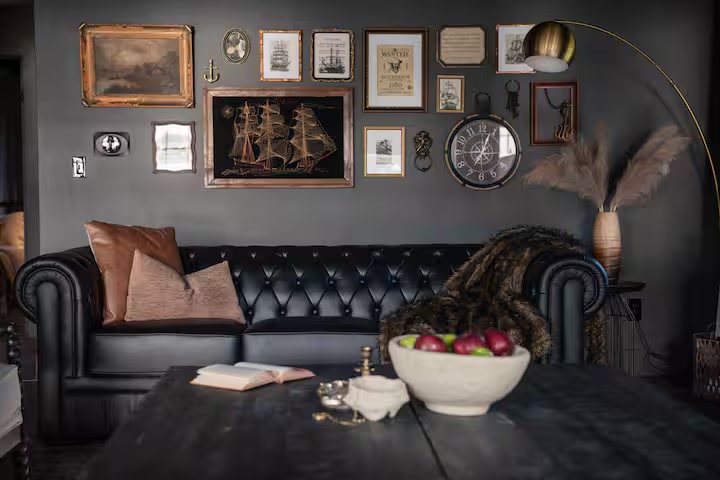 Leather lounge with maritime gallery wall and a table set for a slow afternoon